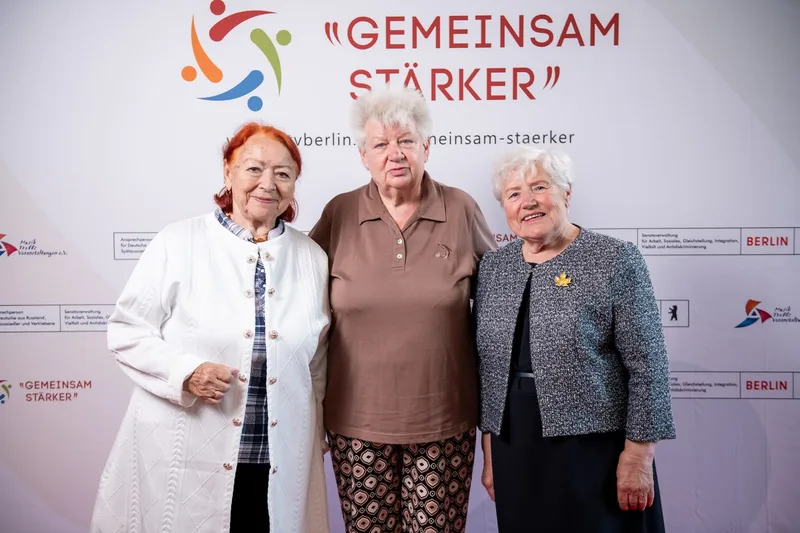 Drei Frauen posieren vor der Presswand Gemeinsam stärker