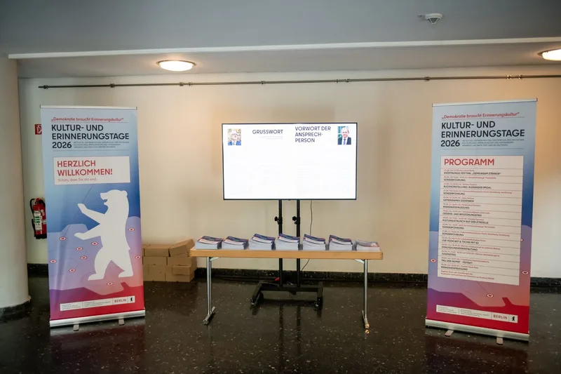 Informationsfoyer mit Bannern, Tisch und Bildschirm