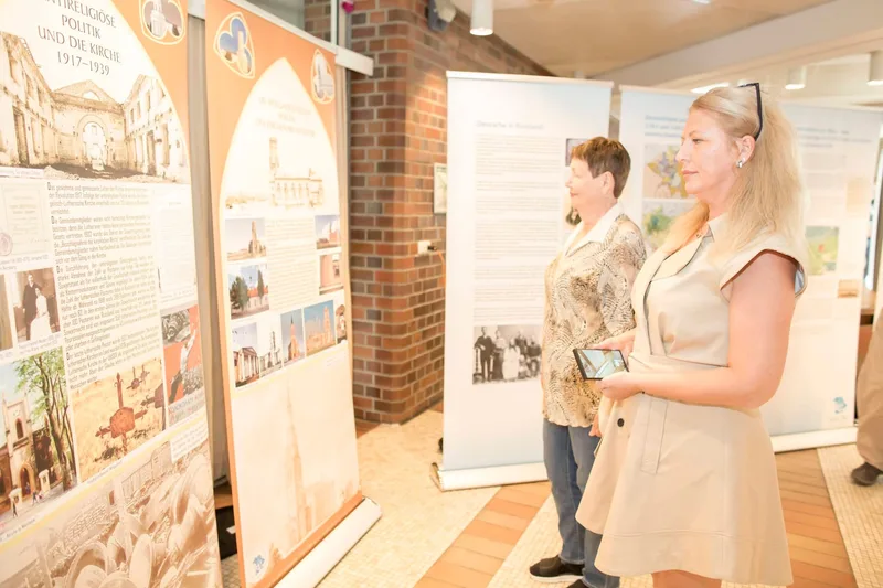 Zwei Frauen studieren Ausstellungspanel mit historischen Fotos