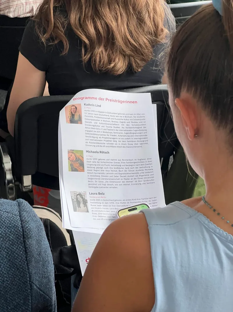Zwei Frauen betrachten das Programmheft mit Preisträgerfotos
