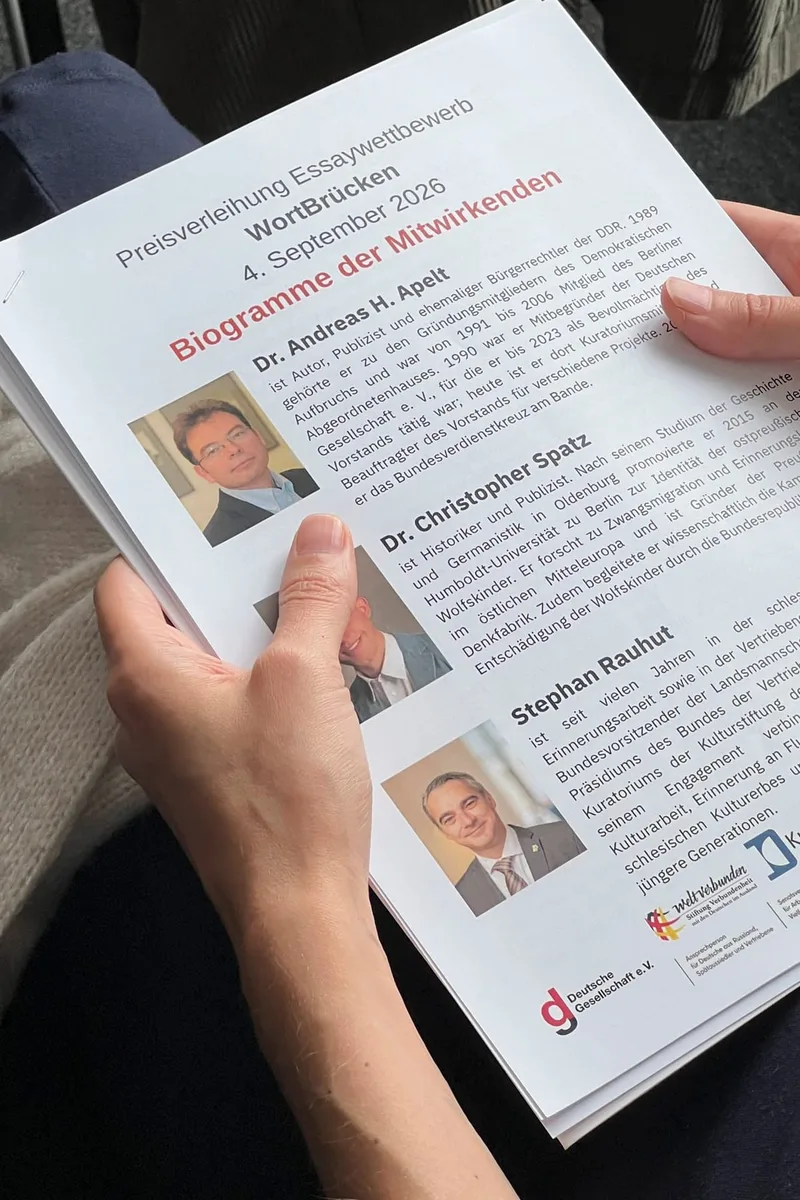 Hände halten das Programmheft mit den Preisträgerangaben