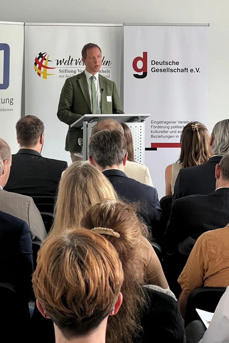 Ein Sprecher am Rednerpult adressiert das Publikum
