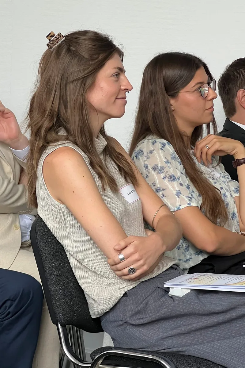 Zwei junge Frauen sitzen konzentriert beim Zuhören